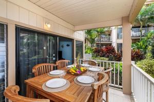 a wooden table and chairs on a balcony with a table at Sea Village 2106 in Kailua-Kona +31 photos