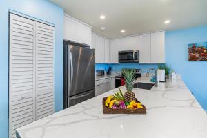 a kitchen with a bowl of fruit on a counter at Sea Village 2106 in Kailua-Kona