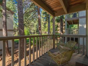 a porch with a rocking chair and trees at Bear's Den in Kings Beach