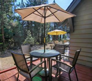 a table and chairs with an umbrella on a deck at McCarthy Place in Tahoe Vista