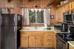 a kitchen with a stainless steel refrigerator and a sink at Honey Bear Cabin in Carnelian Bay