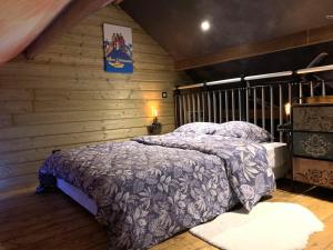 a bedroom with a bed in a wooden wall at Le Garage in Lamotte-Beuvron