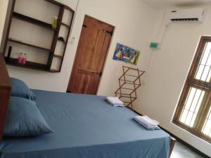 a bedroom with a blue bed and a wooden door at Evara Homestay in Monaragala