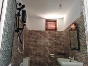 a bathroom with a sink and a mirror at Evara Homestay in Monaragala
