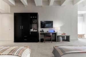 a bedroom with a bed and a desk with a television at Stanton House El Paso in El Paso