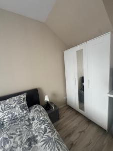 a bedroom with a bed and a large white cabinet at Straume in Valmiera