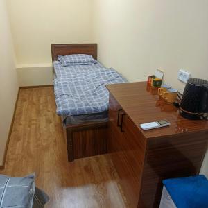 a bedroom with a bed and a wooden desk at Bro Hostel Angor in Termiz