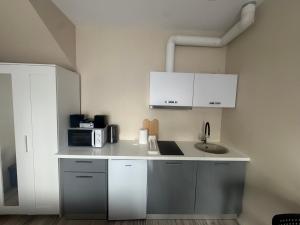 a kitchen with white cabinets and a sink at Straume in Valmiera