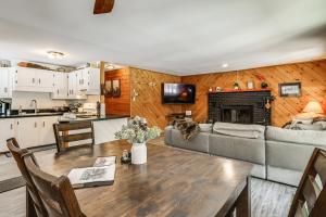 a kitchen and living room with a table and a couch at Riverfront Cabin w/ Hot Tub in Schroon Lake! in Schroon Lake