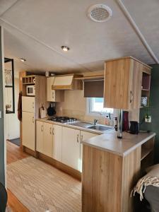 a kitchen with white cabinets and a counter top at Olm29 Vakantiewoning in het Drents Friese Wold vlakbij Diever Zwembad, Animatie, Restaurant, Wandelen, Natuur in Oude Willem