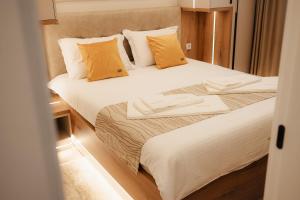two beds in a small room with yellow pillows at Central Premium Suites in Plovdiv