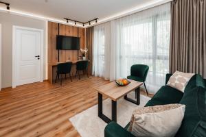 a living room with a green couch and a table at Central Premium Suites in Plovdiv