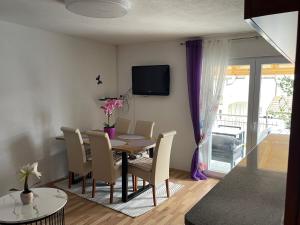 a dining room with a table and chairs and a television at Apartments Ana Kroatien Vodice in Vodice
