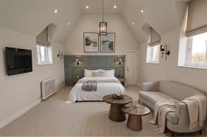 a bedroom with a bed and a couch and a tv at The Highfield - Self Check-in Hotel in Keswick