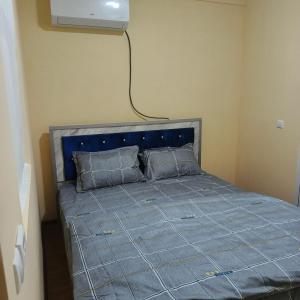 a bedroom with a bed with a blue comforter at Bro Hostel Angor in Termiz