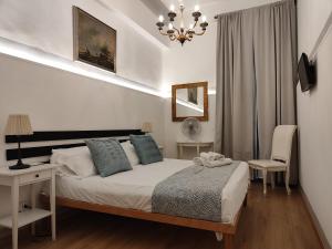 a bedroom with a bed and a desk and a chandelier at Short Lets Grandi Stazioni in Bari