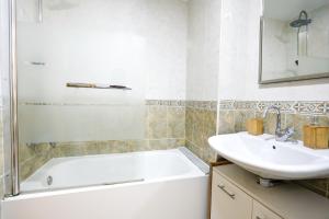 a bathroom with a white tub and a sink at Playa Oliva Apartment in Playa