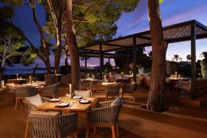 a restaurant with tables and chairs and a gazebo at The St. Regis Mardavall Mallorca Resort in Portals Nous