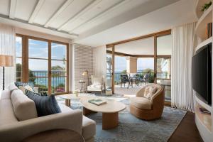 a living room with a couch and chairs and a television at The St. Regis Mardavall Mallorca Resort in Portals Nous