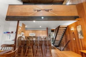 a kitchen with four bar stools and a staircase at Corwin's Quarters in Kings Beach