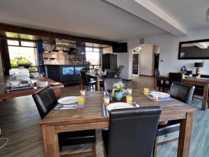 a dining room with a wooden table and chairs at Beachwood Inn Melkbosstrand in Cape Town