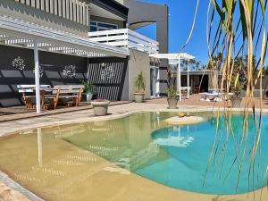 a swimming pool in the backyard of a house at Beachwood Inn Melkbosstrand in Cape Town