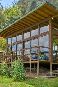 a large building with glass windows at Cúspide Lodge - Choachí in Choachí