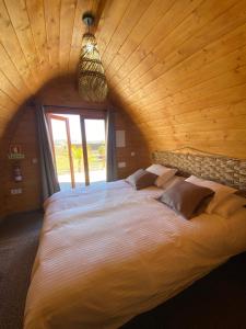 a large bed in a room with a wooden ceiling at Triarca Vinum House in Sabrosa