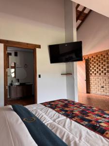 a bedroom with a bed with a flat screen tv on the wall at Hotel Cala in Cucaita