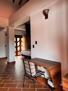 a room with a wooden table and a chair at Hotel Cala in Cucaita