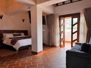a bedroom with a bed and a couch in a room at Hotel Cala in Cucaita