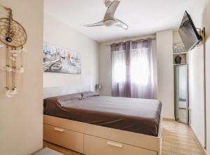 a small bedroom with a bed and a window at Playa Oliva Apartment in Playa