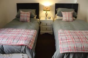 two beds sitting next to each other in a bedroom at Alexandra Apartment - stunning view in Oban