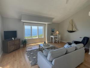 a living room with a couch and a tv at Great Hill in Kennebunk