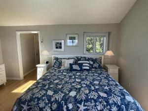 a bedroom with a bed with a blue and white bedspread at Great Hill in Kennebunk