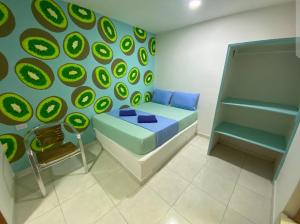 a room with a bed and a wall with green circles at Tamarindo in Santa Marta