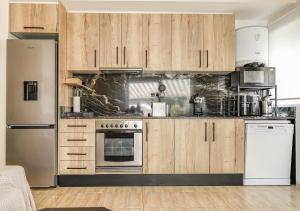 a kitchen with wooden cabinets and a white appliance at Playa Oliva Apartment in Playa +3 photos