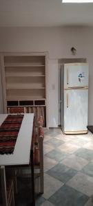a kitchen with a table and a refrigerator at El Legado in San Pedro
