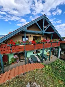 a house with a balcony with flowers on it at Penzion Ranch FAH in Spišské Podhradie