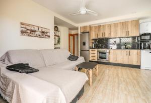 a living room with a couch and a kitchen at Playa Oliva Apartment in Playa