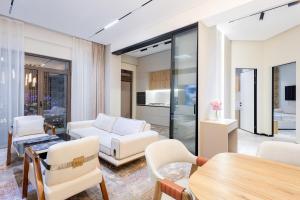 a living room with white furniture and a table at Luxury 98m2, City Boulevard View, Fountain View, Tashkent City in Tashkent +60 photos