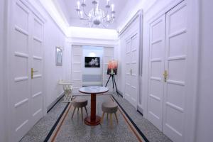 a hallway with white doors and a table and stools at Short Lets Grandi Stazioni in Bari +4 photos