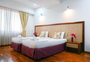 a hotel room with two beds and a large window at City5 ROOMS & SUITES by LSA in Skopje