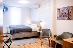a bedroom with a bed and a table and chairs at Rooms Ikar in Velika Gorica