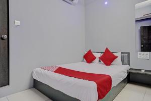 a bedroom with a bed with red pillows at The Bull Group International in Surat