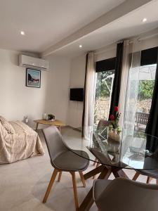 a living room with a glass table and chairs at Mazets sous le pin in Le Rouret