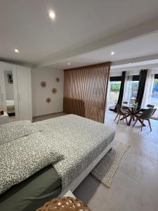 a bedroom with a large bed and a table and chairs at Mazets sous le pin in Le Rouret