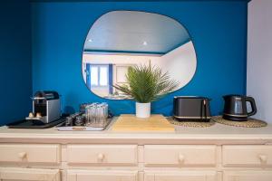 a counter with a mirror on a blue wall at SBredele - Maison de ville cosy - hypercentre in Sélestat +6 photos