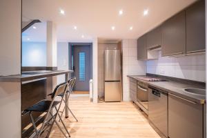 a kitchen with stainless steel appliances and wooden floors at SBredele - Maison de ville cosy - hypercentre in Sélestat