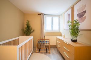 a room with a crib and plants in it at SBredele - Maison de ville cosy - hypercentre in Sélestat
